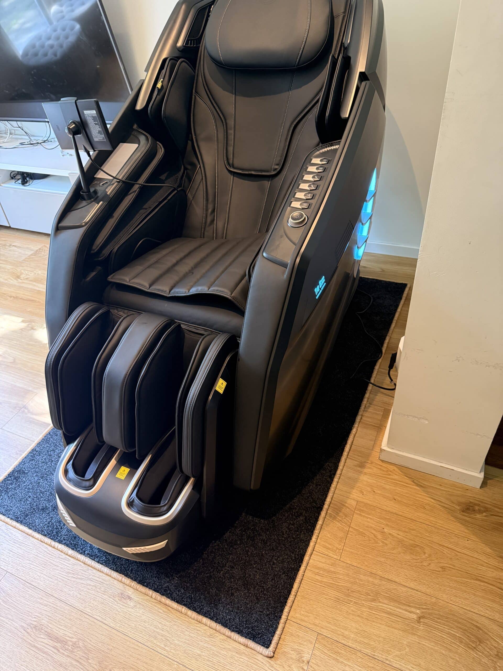 Massagestol på massagematta i modern hemmiljö med LED-belysning och premiumdesign